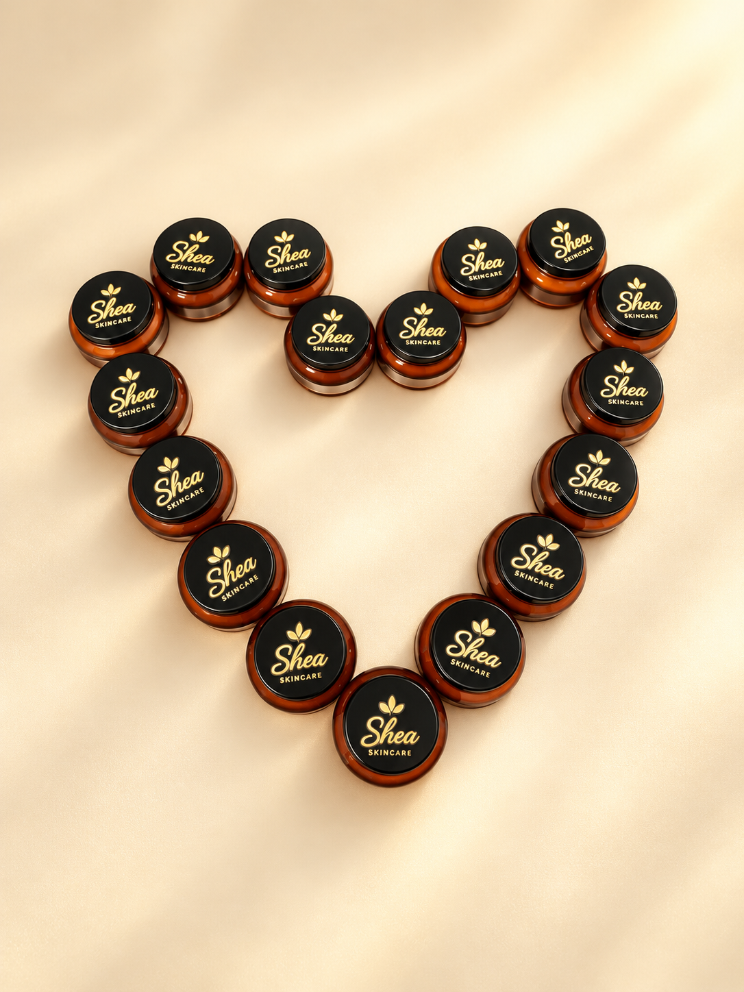 Shea skincare jars arranged in a heart on a soft cream and gold background